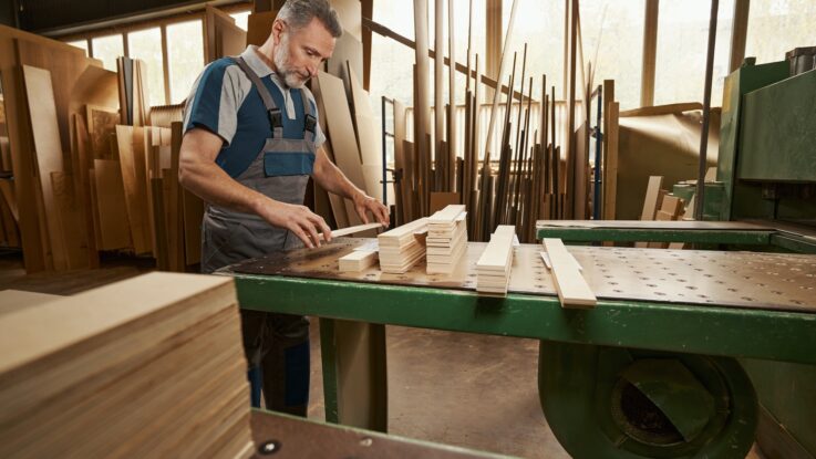 Attentive male person working at furniture manufacture